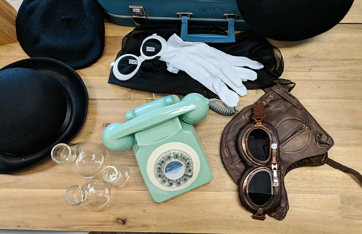 Signature props for a brand photoshoot including a retro phone, old-timey airplane pilot goggles