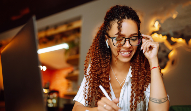 Woman at computer designing marketing materials with Adobe Express